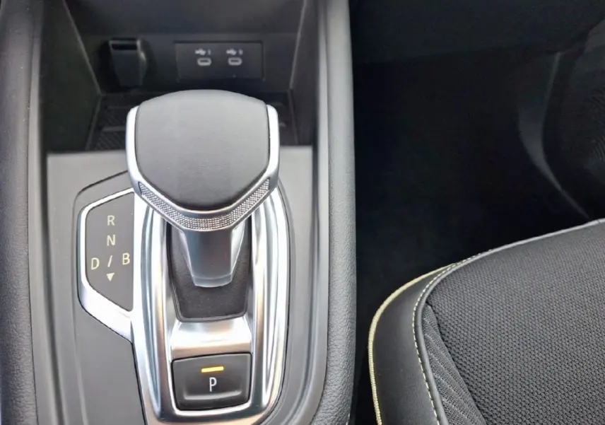 Gros plan sur la commande de boîte automatique noire et argentée du Renault Symbioz Iconic E-Tech 145, côté droit du siège.