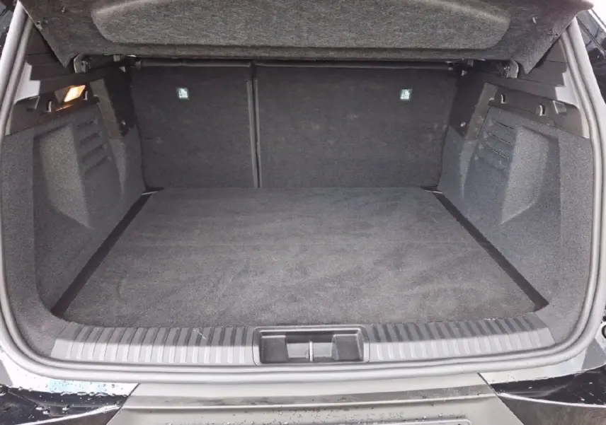Coffre ouvert vu de l'arrière d'une Renault SYMBIOZ noire, espace de chargement propre et spacieux.