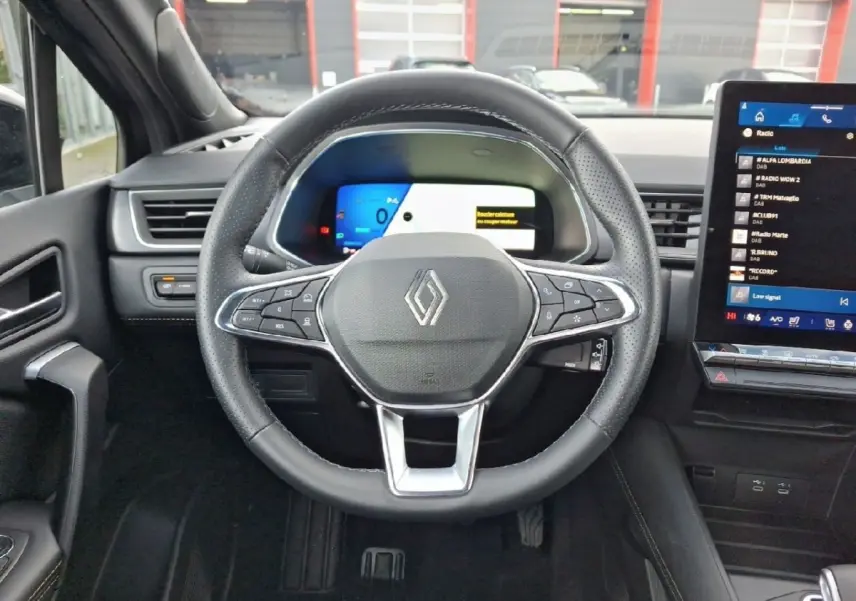 Vue frontale du volant noir de la Renault SYMBIOZ 2025 avec tableau de bord digital et écran tactile central.