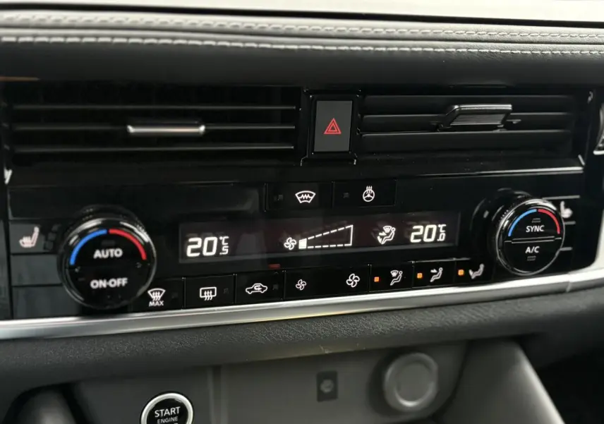 Détail de la console centrale du Nissan Qashqai 2024, montrant la climatisation automatique bi-zone et les commandes chauffantes.