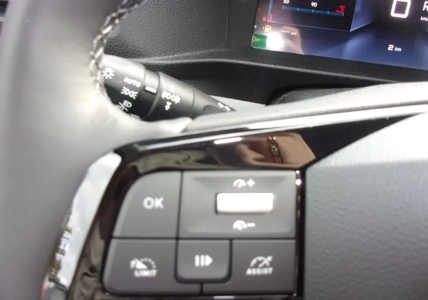 Gros plan sur les commandes au volant noir du Citroën Jumpy Cabine Approfondie, avec combiné numérique en arrière-plan.