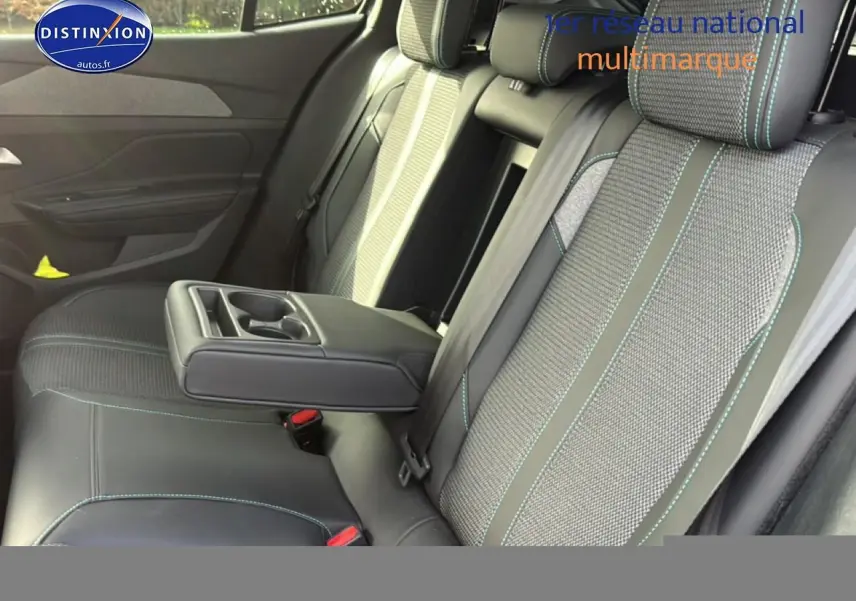 Vue intérieure des sièges arrière de la Peugeot 408 Hybrid 145 allure, avec accoudoir central et sellerie bicolore.