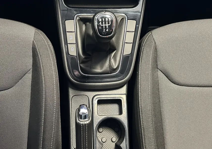 Vue plongeante sur la console centrale d'une Skoda Fabia 2023 gris, avec levier de vitesse manuel et frein à main.