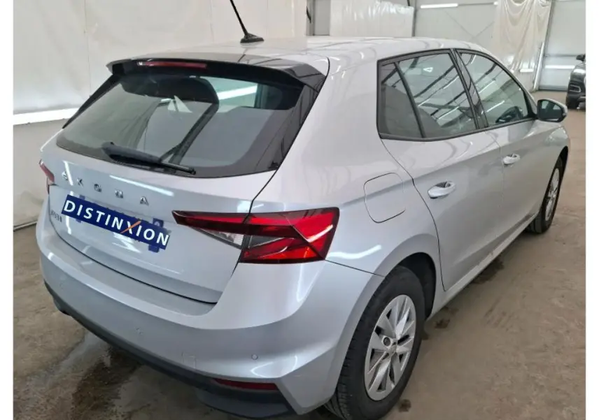 Vue 3/4 arrière droite d'une Skoda Fabia gris clair 2023 avec feux arrière LED et antenne sur le toit.