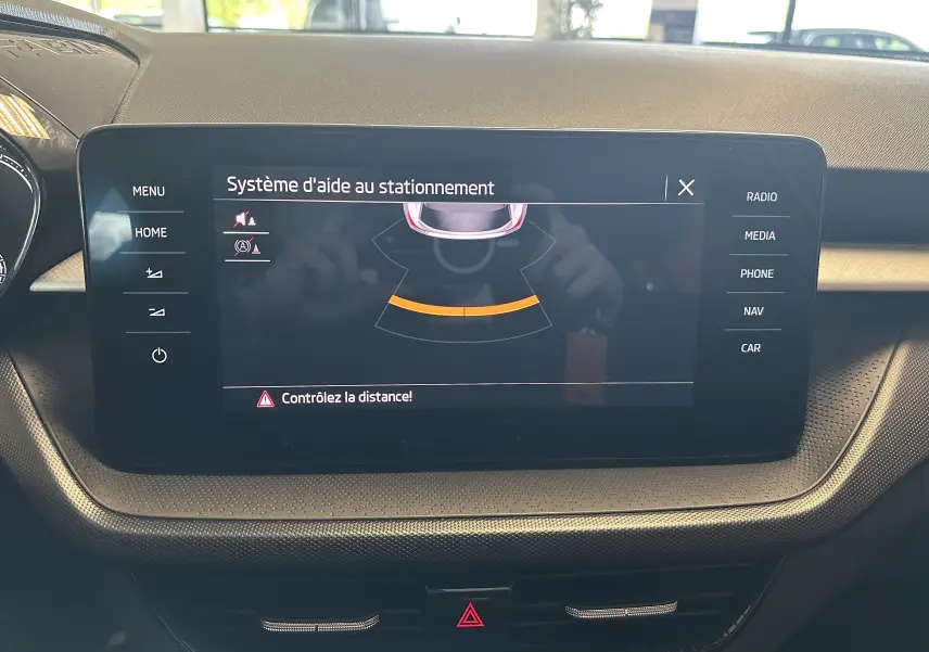 Écran central tactile du tableau de bord de la Skoda Fabia Ambition 2023 affichant l'aide au stationnement.