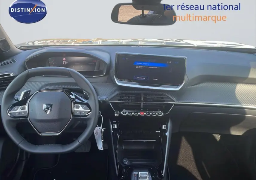 Vue intérieure frontale du tableau de bord gris du Peugeot 2008 1.2 Hybrid 145ch avec écran tactile et volant cuir multifonction.