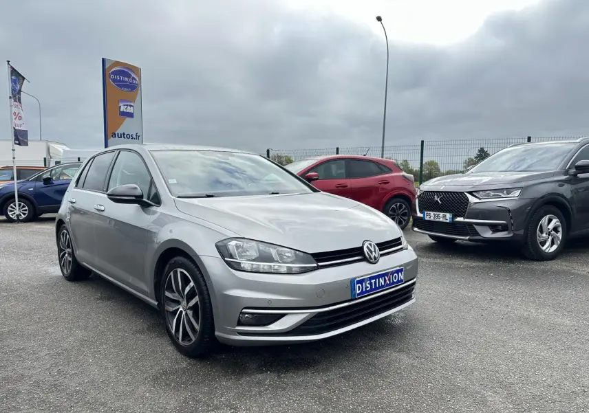 Volkswagen Golf VII gris foncé vue 3/4 avant avec jantes alliage 17 pouces sur parking extérieur.