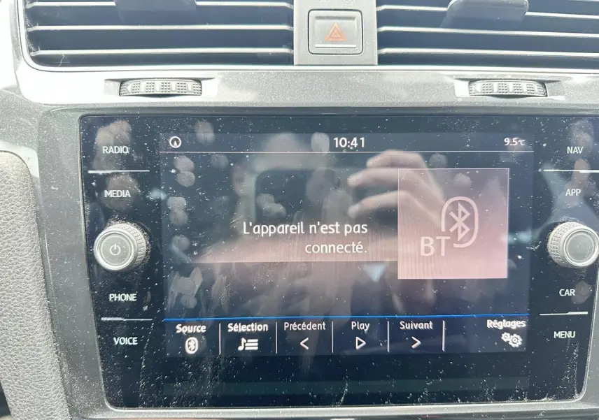 Gros plan sur l'écran tactile central du Volkswagen Golf gris foncé, affichant un message Bluetooth non connecté.