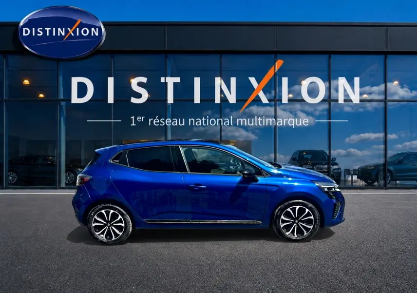 Renault Clio V bleu iron vue de profil côté gauche, avec jantes alu et vitres arrière surteintées.