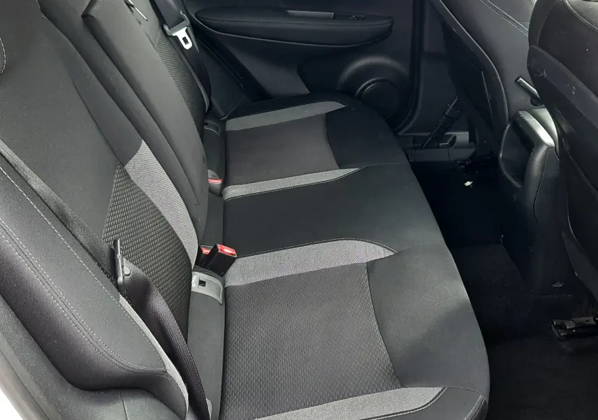 Vue intérieure côté gauche des sièges arrière en tissu gris et noir du Nissan Qashqai blanc 2018, avec ceinture de sécurité visible.