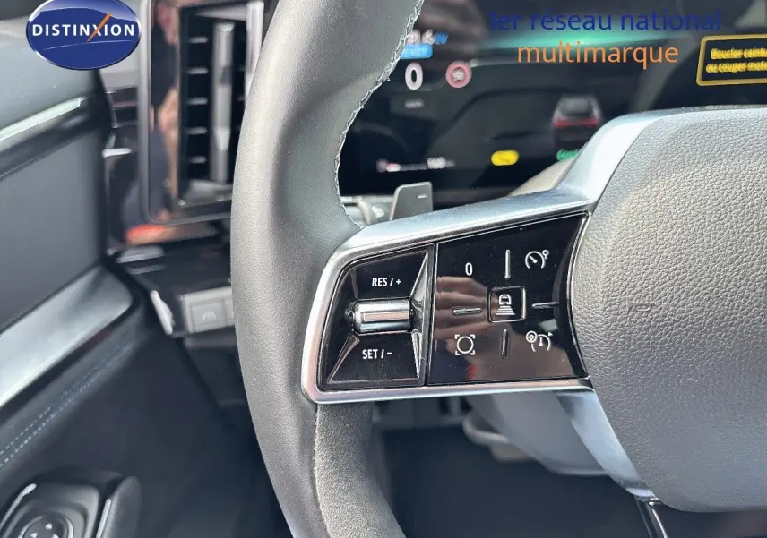 Gros plan sur le volant du Renault Austral 2024 avec commandes de régulateur et tableau de bord numérique en arrière-plan.