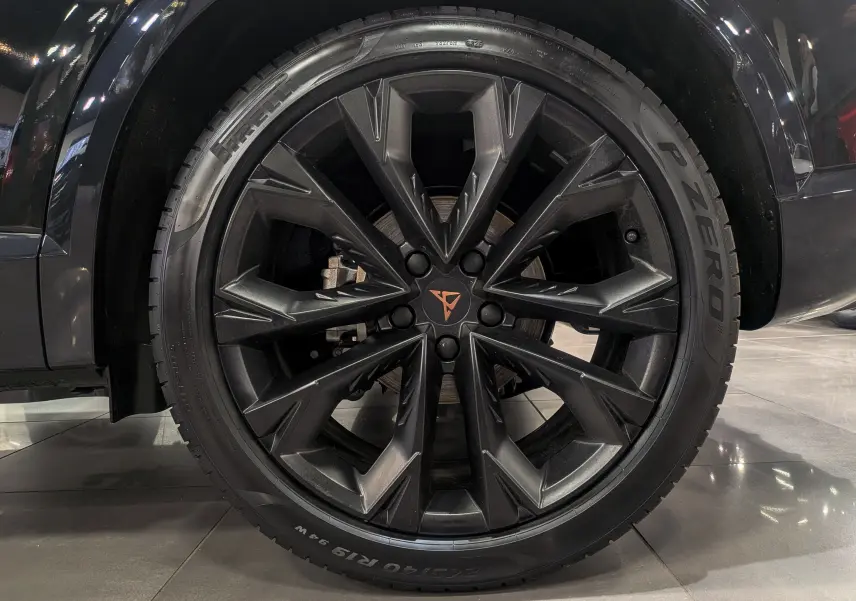 Gros plan sur la roue avant droite noire Minuit d'une CUPRA Formentor eHybrid 2025 avec jante noire au logo CUPRA orange.