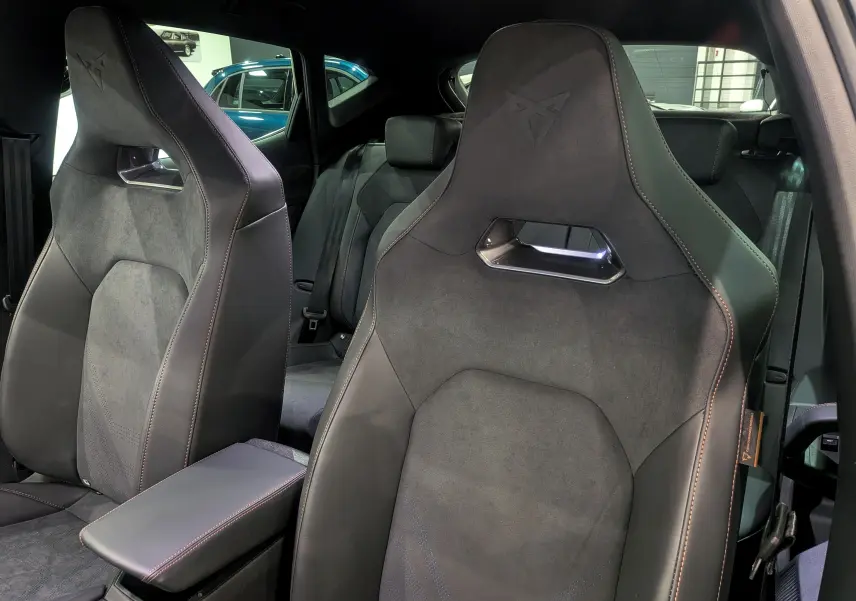 Vue rapprochée des sièges avant en cuir noir et alcantara du CUPRA Formentor eHybrid 2025 avec logo embossé et surpiqûres contrastées.