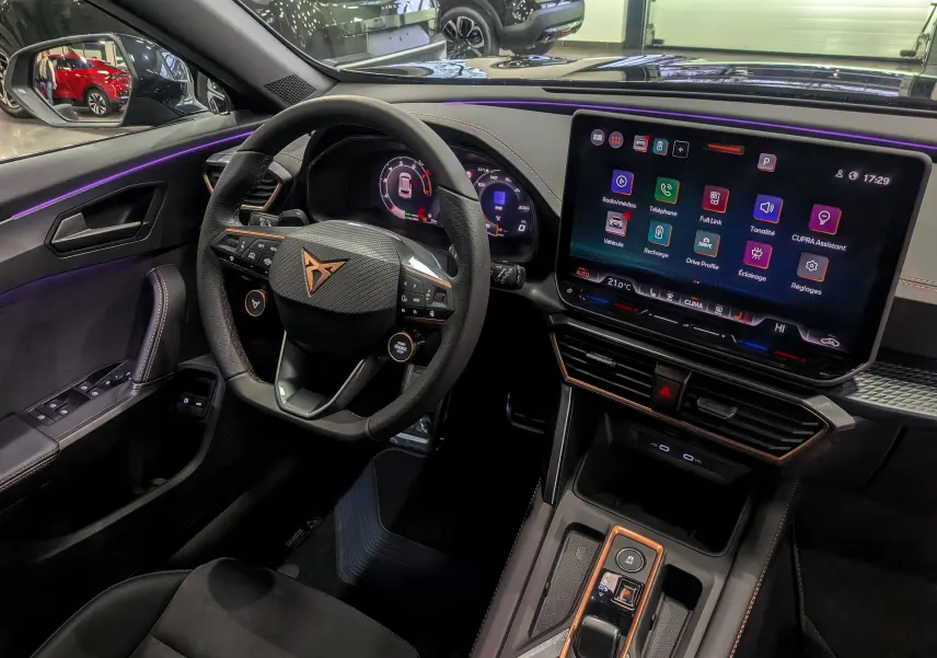 Vue intérieure côté conducteur du CUPRA Formentor eHybrid 2025 noir, avec tableau de bord digital et écran tactile central lumineux.