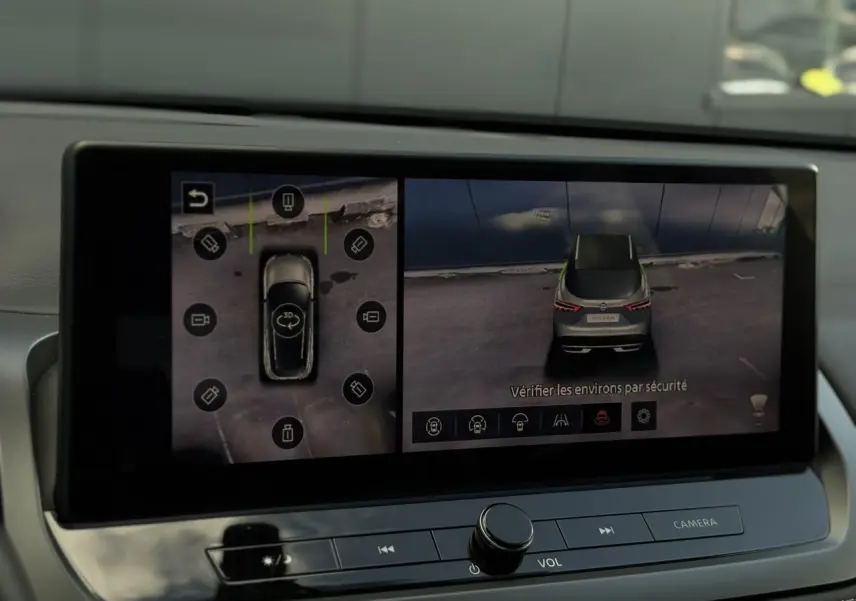 Écran intérieur affichant la caméra 360° du Nissan Qashqai gris Ceramic, vue arrière et dessus du véhicule.
