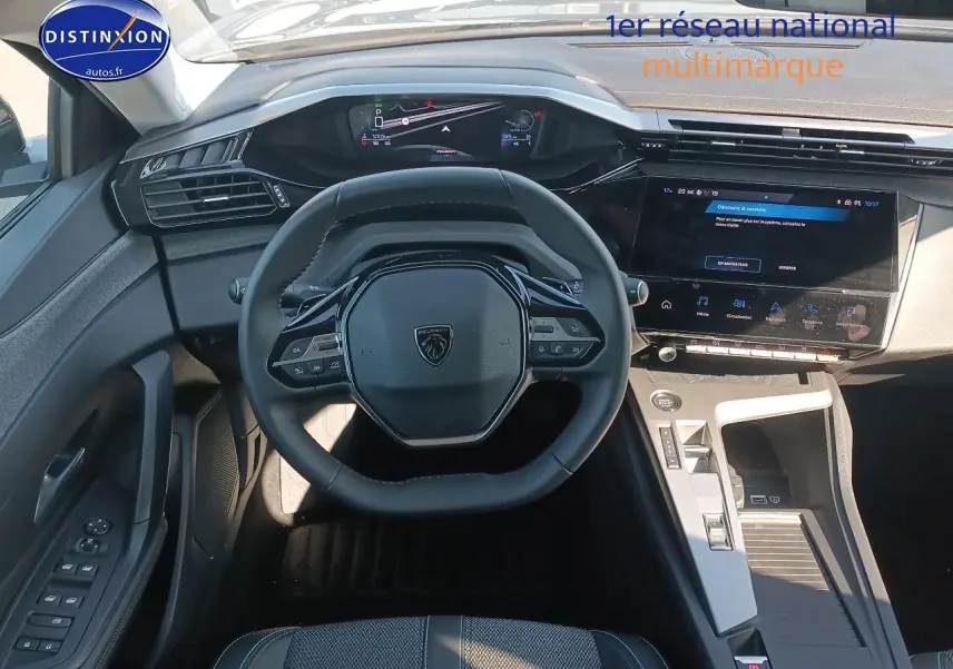 Vue intérieure frontale du poste de conduite du Peugeot 408 gris sélénite, avec volant cuir et écran tactile central.