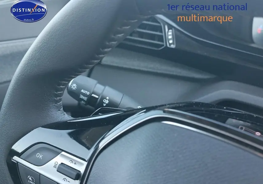 Gros plan sur le volant cuir noir du Peugeot 408 Hybrid 145 allure e-dcs6, avec commandes intégrées visibles.