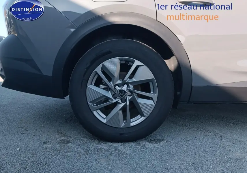 Gros plan sur la roue arrière gauche de la Peugeot 408 gris sélénite avec jante alu au design moderne.