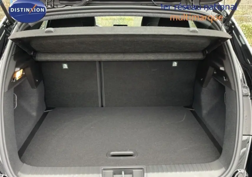 Coffre ouvert vu de l'arrière d'un Renault Captur noir 2025, espace de chargement vide avec cache-bagages relevé.