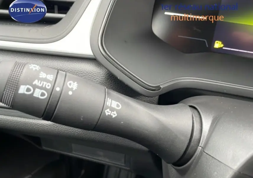 Gros plan sur la commande d'allumage automatique des feux du tableau de bord du Renault Captur noir 2025.