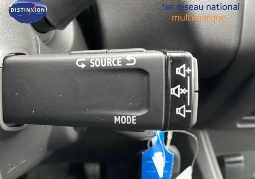 Gros plan sur la commande au volant du Renault Captur noir 2025, avec boutons source et mode visibles.