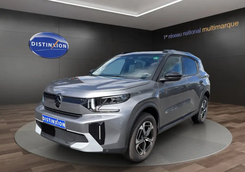 Vue 3/4 avant droite du Citroën C3 Aircross électrique gris foncé avec jantes distinctives et toit noir.