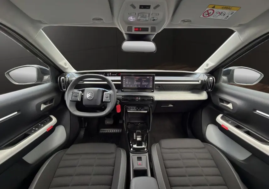 Vue intérieure avant du Citroën C3 Aircross gris foncé, tableau de bord moderne avec écran tactile central et volant multifonctions.
