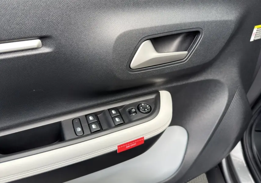 Gros plan sur la porte côté conducteur de la Citroën C3 Aircross gris foncé, avec commandes de vitres et poignée intérieure.
