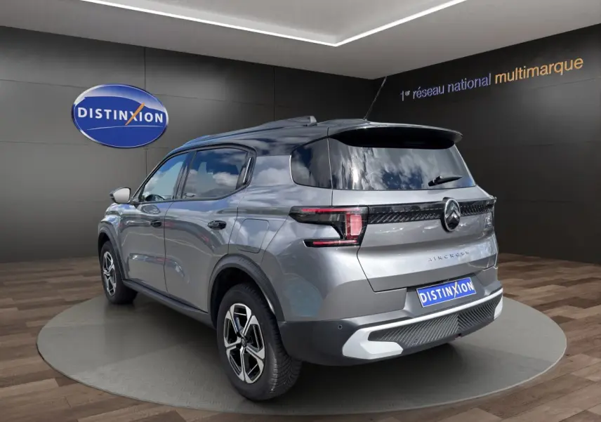 Vue 3/4 arrière droite d’un Citroën C3 Aircross électrique gris foncé avec feux LED et toit noir brillant.