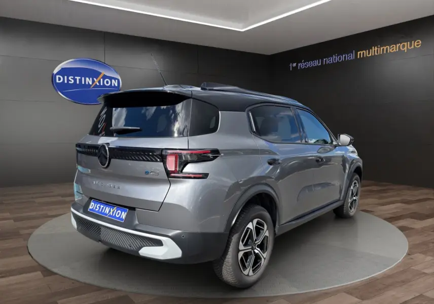 Vue 3/4 arrière droite d'une Citroën C3 Aircross électrique gris foncé avec toit noir et jantes distinctives.