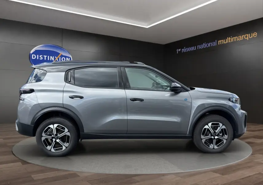 Profil droit du Citroën C3 Aircross électrique gris foncé 2025 avec jantes modernes et barres de toit noires.