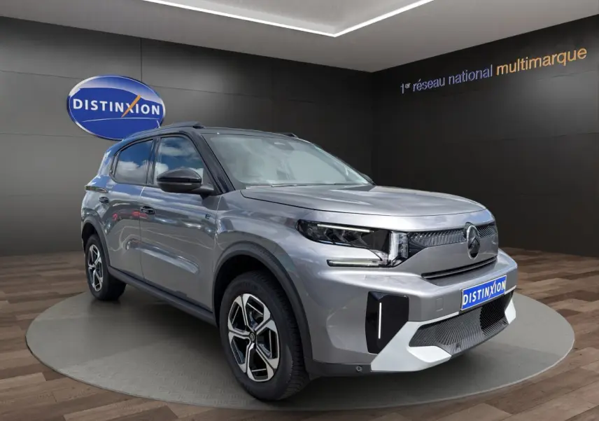 Vue 3/4 avant d'un Citroën C3 Aircross électrique gris foncé avec jantes stylisées et calandre moderne.