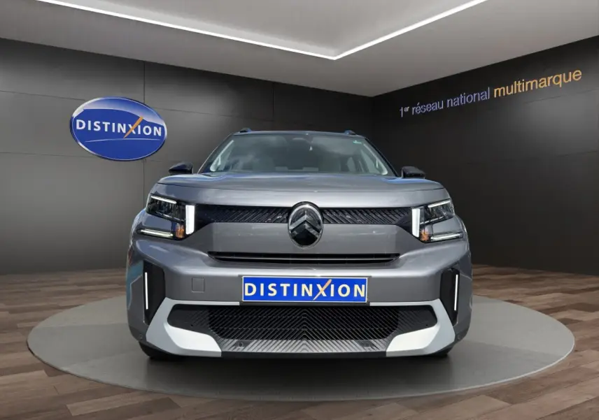 Vue frontale d'un Citroën C3 Aircross électrique gris foncé avec feux LED verticaux et logo distinctif au centre.