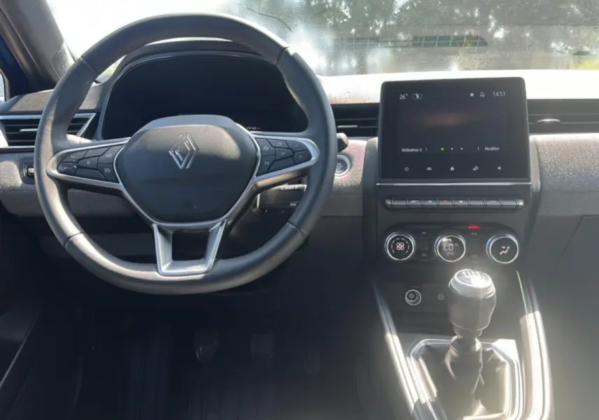 Vue de face de l'intérieur de la Renault Clio V 1.0 TCe 90 Techno avec volant multifonction et écran tactile central.