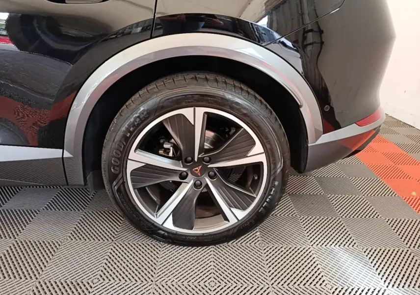 Gros plan sur la roue arrière droite noire du CUPRA Formentor 1.4 e-HYBRID 2024 avec jante alu bicolore et logo CUPRA central.