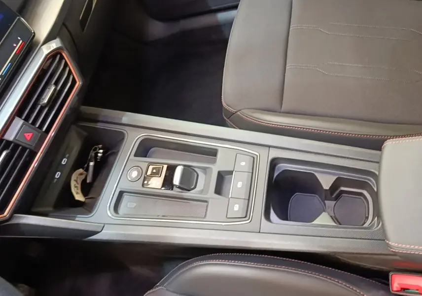 Vue plongeante sur la console centrale noire du CUPRA Formentor 1.4 e-HYBRID avec sélecteur de boîte auto et porte-gobelets.