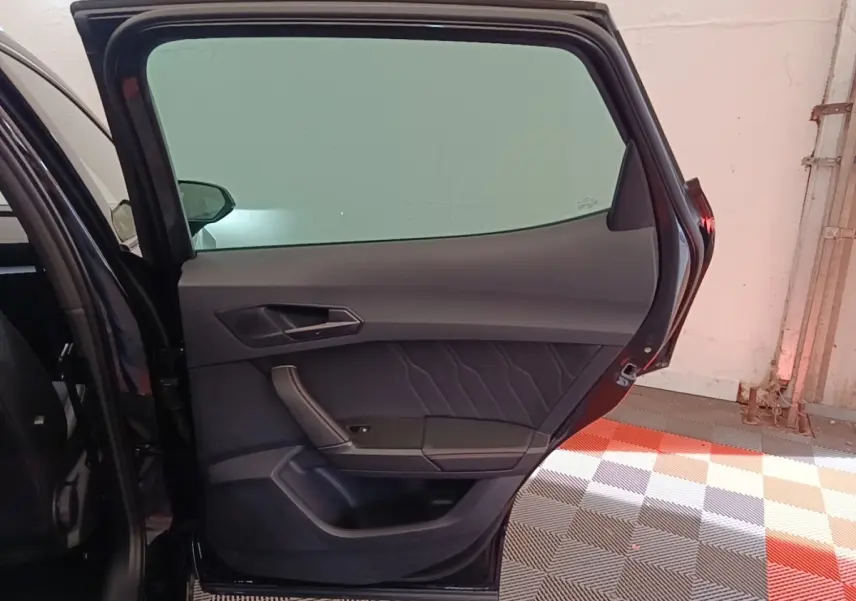 Vue intérieure de la porte arrière gauche noire du CUPRA Formentor 2024, avec garniture en tissu et cuir.