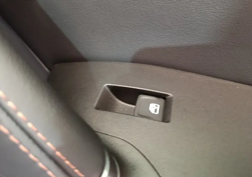 Gros plan sur le bouton d'ouverture de trappe à carburant dans l'habitacle noir du CUPRA Formentor 2024.
