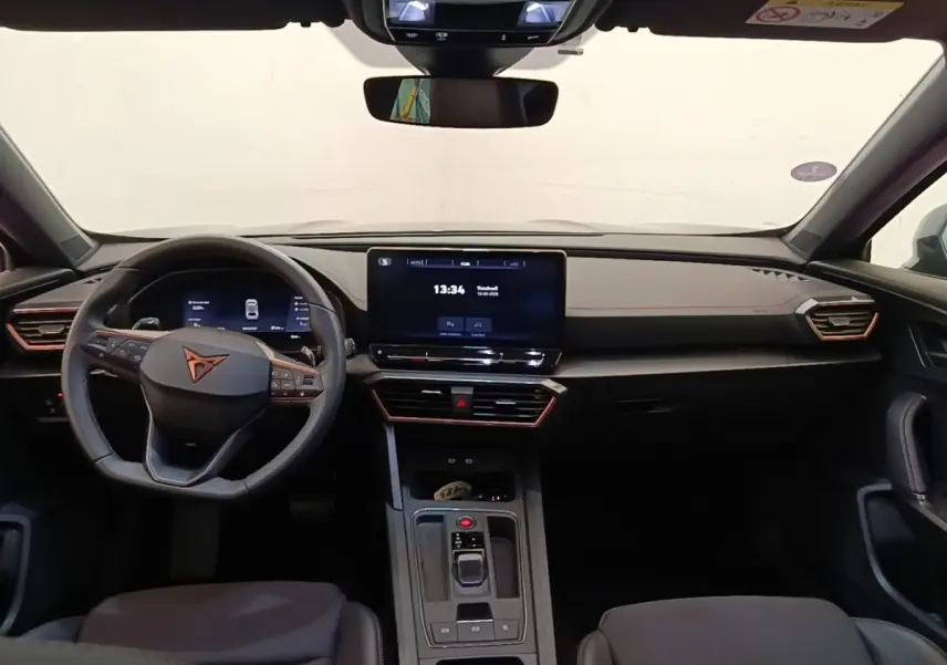 Vue intérieure frontale du tableau de bord noir du CUPRA Formentor 1.4 e-HYBRID avec écran tactile central et volant multifonctions.