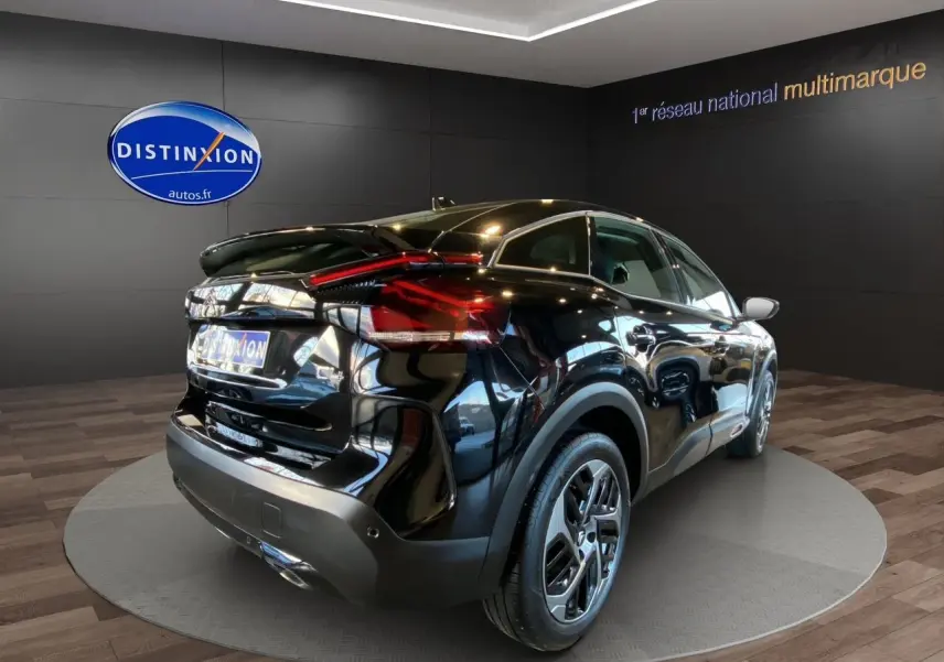 Vue 3/4 arrière droite d'une Citroën C4 2023 noire Perla Nera avec feux arrière LED et jantes alliage.