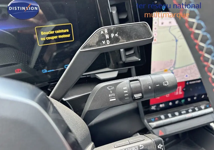 Le levier de vitesses automatique et les commandes au volant du Renault Austral 2024, avec écran tactile en arrière-plan.