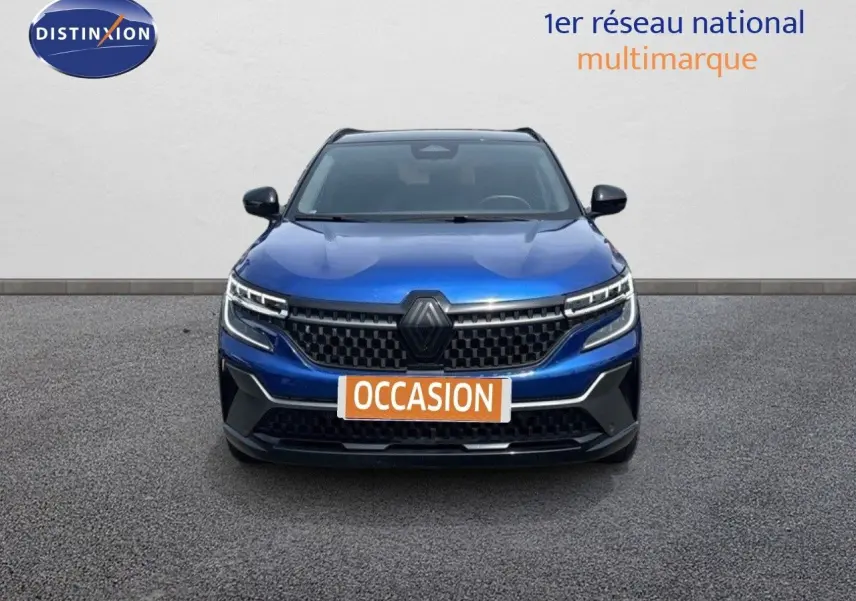 Vue de face du Renault Austral 2024 en bleu Iron avec toit noir, mettant en valeur sa calandre moderne et ses phares LED.