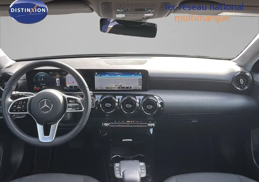 Vue intérieure avant du tableau de bord et volant noir d'une Mercedes Classe A 200D 2021 avec écran tactile et aérateurs ronds.