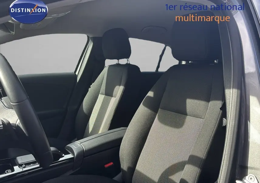 Vue intérieure côté conducteur de la Mercedes Classe A 200D 2021 gris montagne, sièges tissu gris foncé et console centrale.