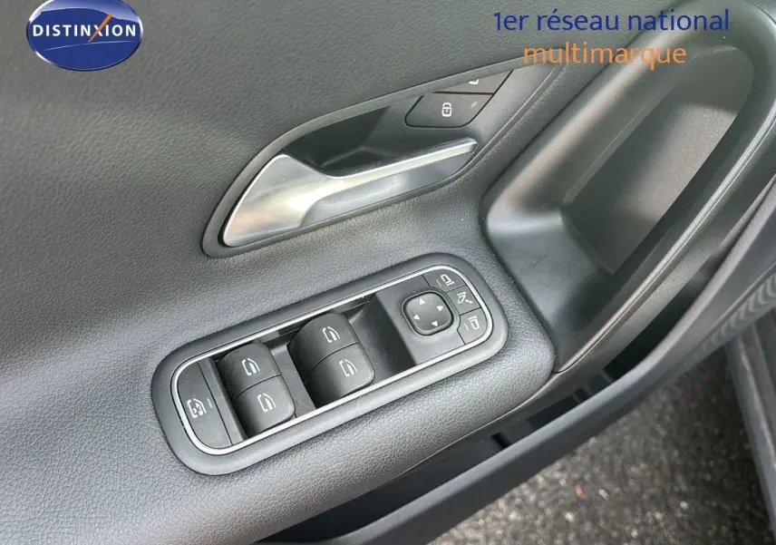Gros plan sur la commande des vitres et rétroviseurs côté gauche de la porte d'une Mercedes Classe A gris montagne métal.