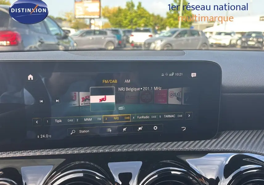 Écran tactile central affichant la radio NRJ dans l'habitacle moderne d'une Mercedes Classe A gris montagne métal.