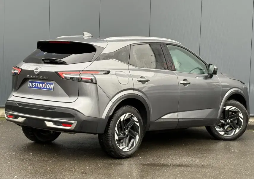Vue 3/4 arrière droite du Nissan Qashqai 2024 gris Squale avec hayon électrique et jantes alliage 18 pouces.