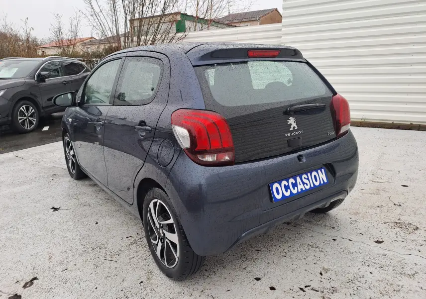 Vue 3/4 arrière droite d'une Peugeot 108 bleu foncé 5 portes avec jantes alliage biton et plaque "OCCASION".