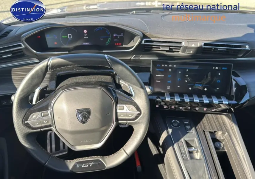 Vue intérieure centrée sur le volant cuir GT et le tableau de bord numérique de la Peugeot 508 SW Hybrid 225 gris Artense.