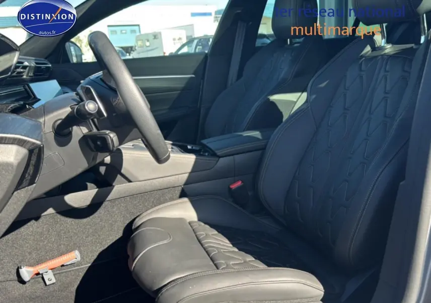 Vue intérieure côté conducteur de la Peugeot 508 SW Hybrid 225 GT e-EAT8 avec sièges en cuir noir et surpiqûres apparentes.